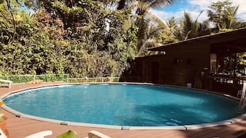 Een buitenzwembad en ligstoelen