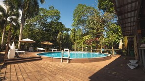 Una piscina al aire libre, tumbonas