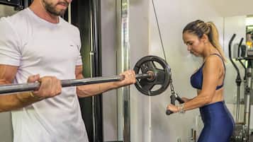 Un gimnasio con equipo de ejercicio, un rack de pesas y un espejo.