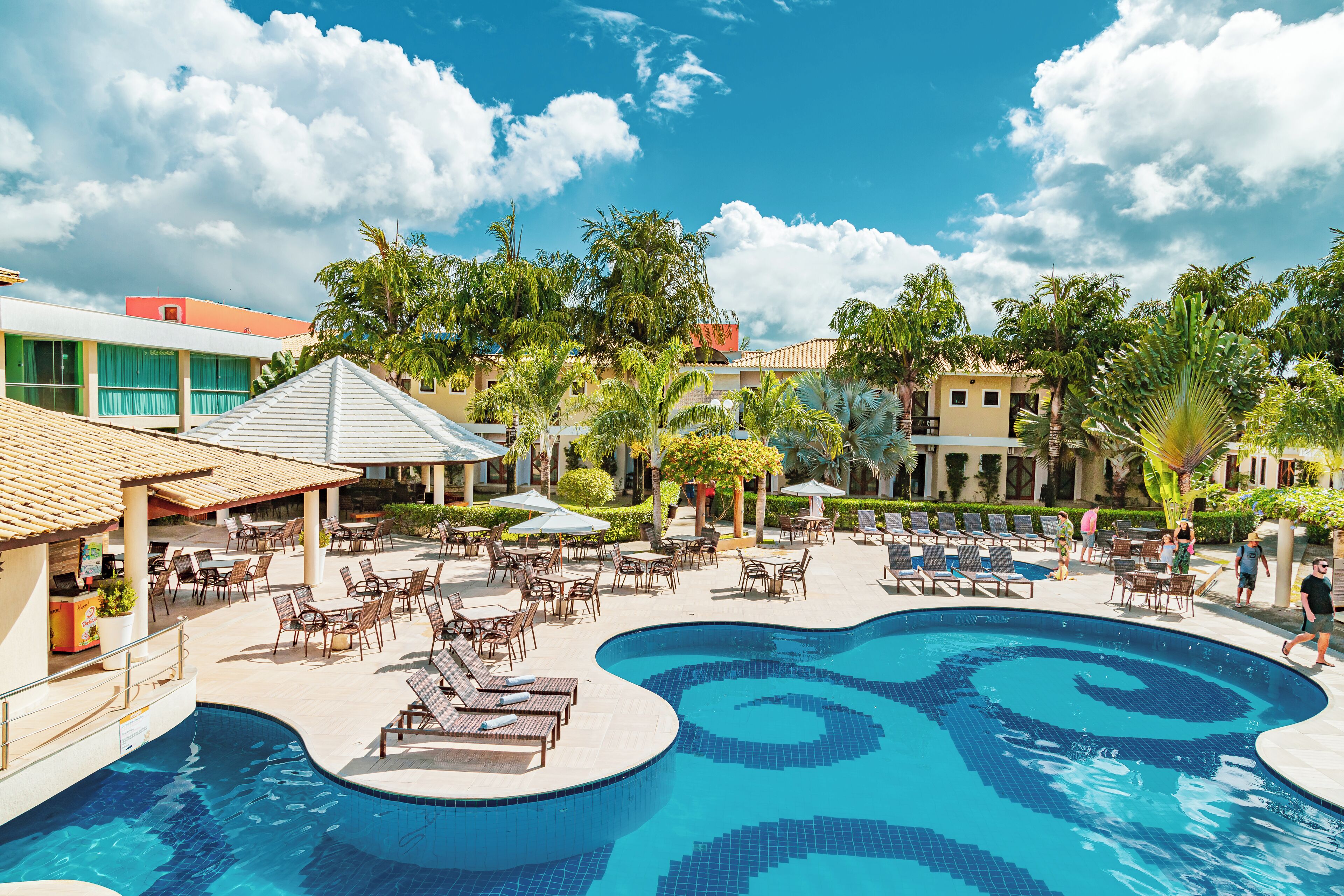 Una piscina al aire libre, sombrillas, sillones reclinables de piscina
