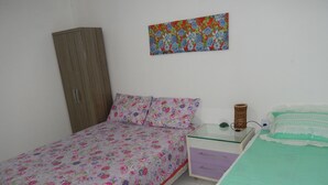Une chambre à coucher comprenant un lit, une table de chevet, une armoire et un tableau accroché au mur.