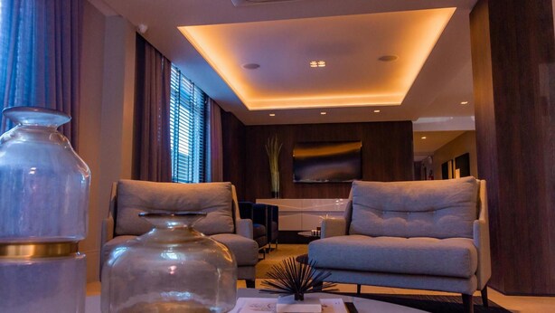 A modern living room with two sofas, a coffee table, and decorative items. - Hotel Kennedy (Sao Jose)