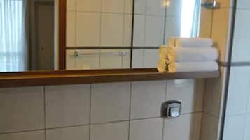 Un baño con lavamanos de granito, inodoro y zona de ducha.
