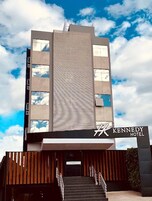Um edifício de hotel moderno com uma placa chamativa do Hotel Kennedy.