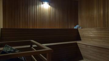 A sauna with wooden benches and a bench with a towel holder.