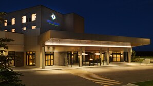 Un hotel con fachada moderna, un acceso cubierto y un exterior bien iluminado.