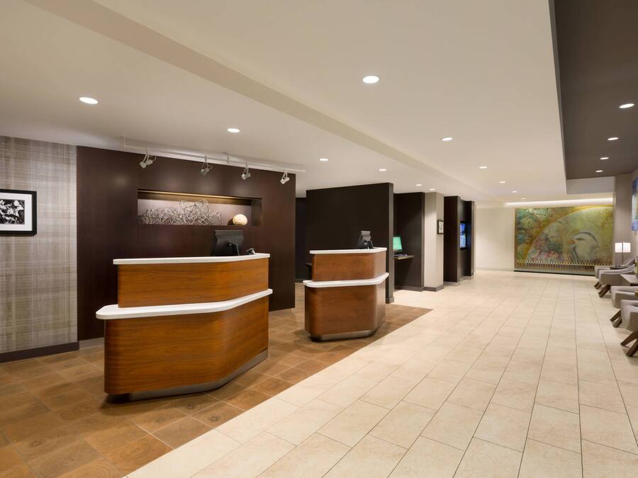 A reception area with a wooden reception desk, a waiting area with chairs, and a large wall mural.