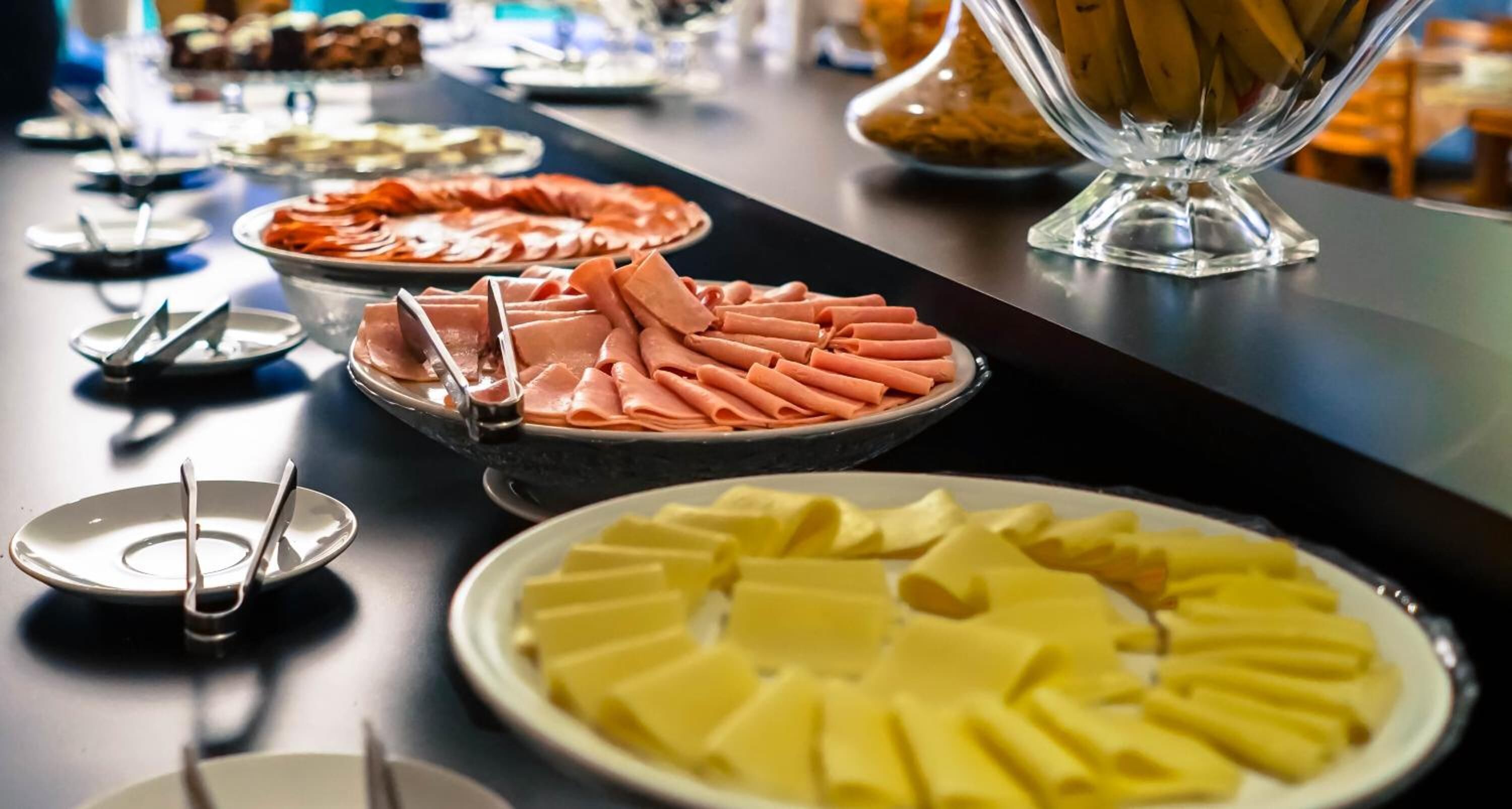 A buffet table with various food items including sliced meats and a pineapple dish.