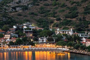 A coastal town with a marina, waterfront buildings, and a hilly backdrop. - Wyndham Datca Perili Bay (Datça)