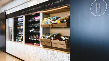 A food display with various packaged items and a sign above reading "What's cold, sweet and melts in your mouth?".