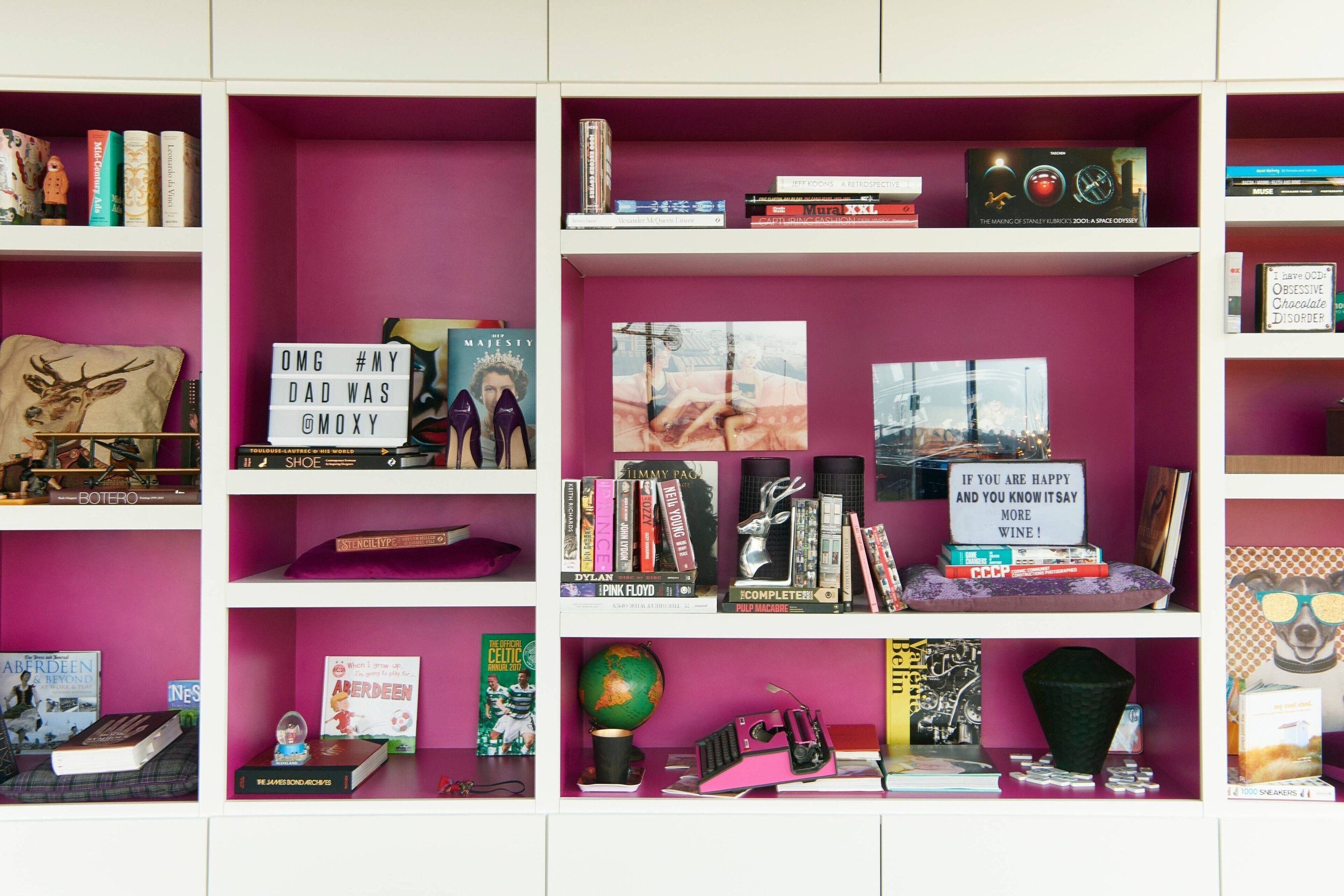 A bookshelf with various books, a globe, and decorative items.