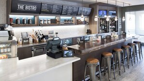 A modern bistro with a bar area, stools, and a menu board.