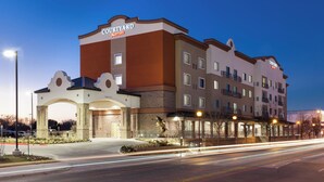 A Courtyard Marriott hotel with a prominent entrance, multiple floors, and a well-lit facade.