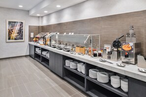 A buffet setup with various food items and serving equipment.