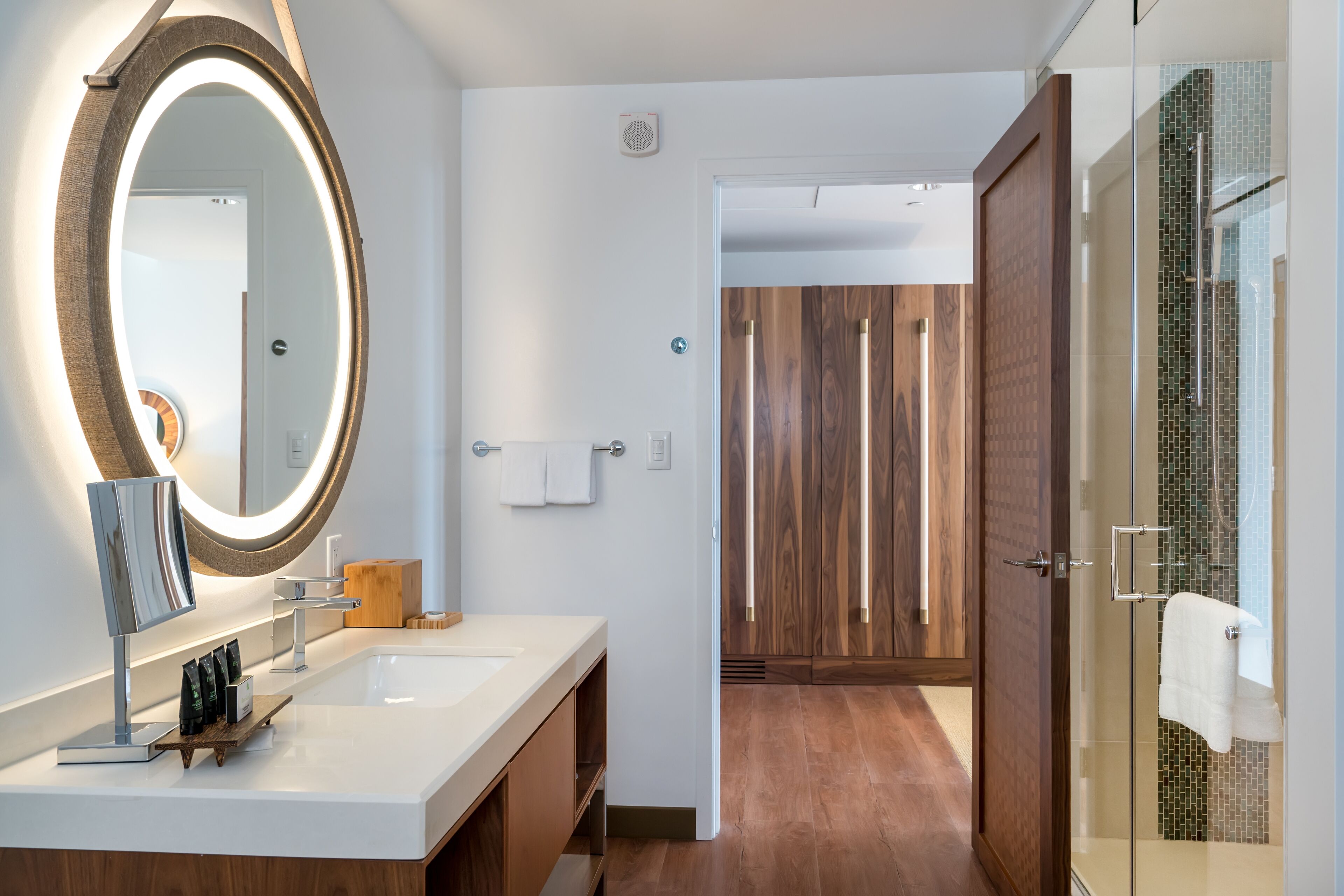 Un baño moderno con un espejo grande, un lavabo y una zona de ducha.