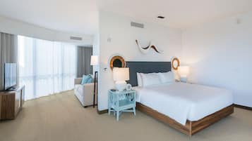 Habitación de hotel con una cama grande, televisión, escritorio y vistas al exterior.
