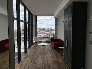 A modern interior with large windows, a wooden floor, and red furniture.