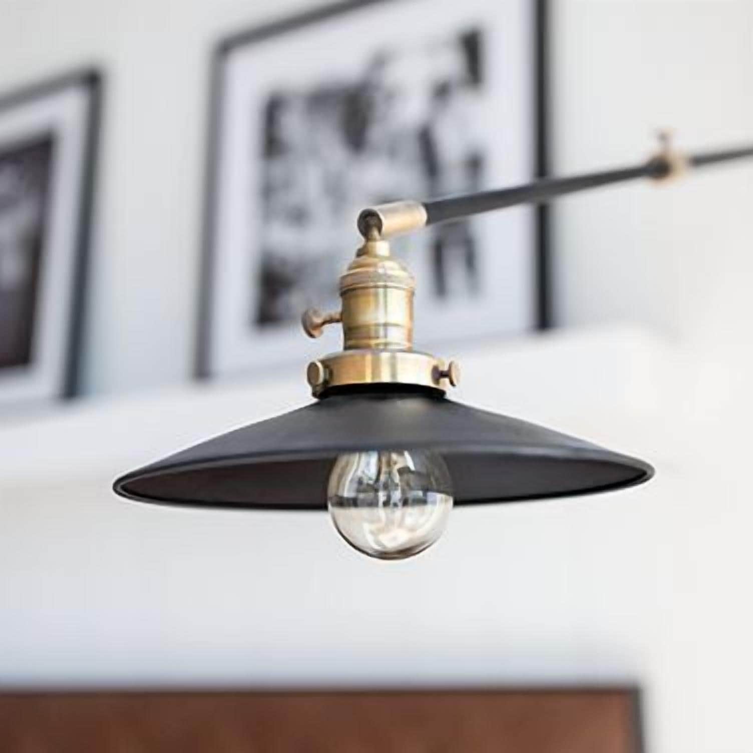 A pendant light fixture with a black shade and a brass finish.