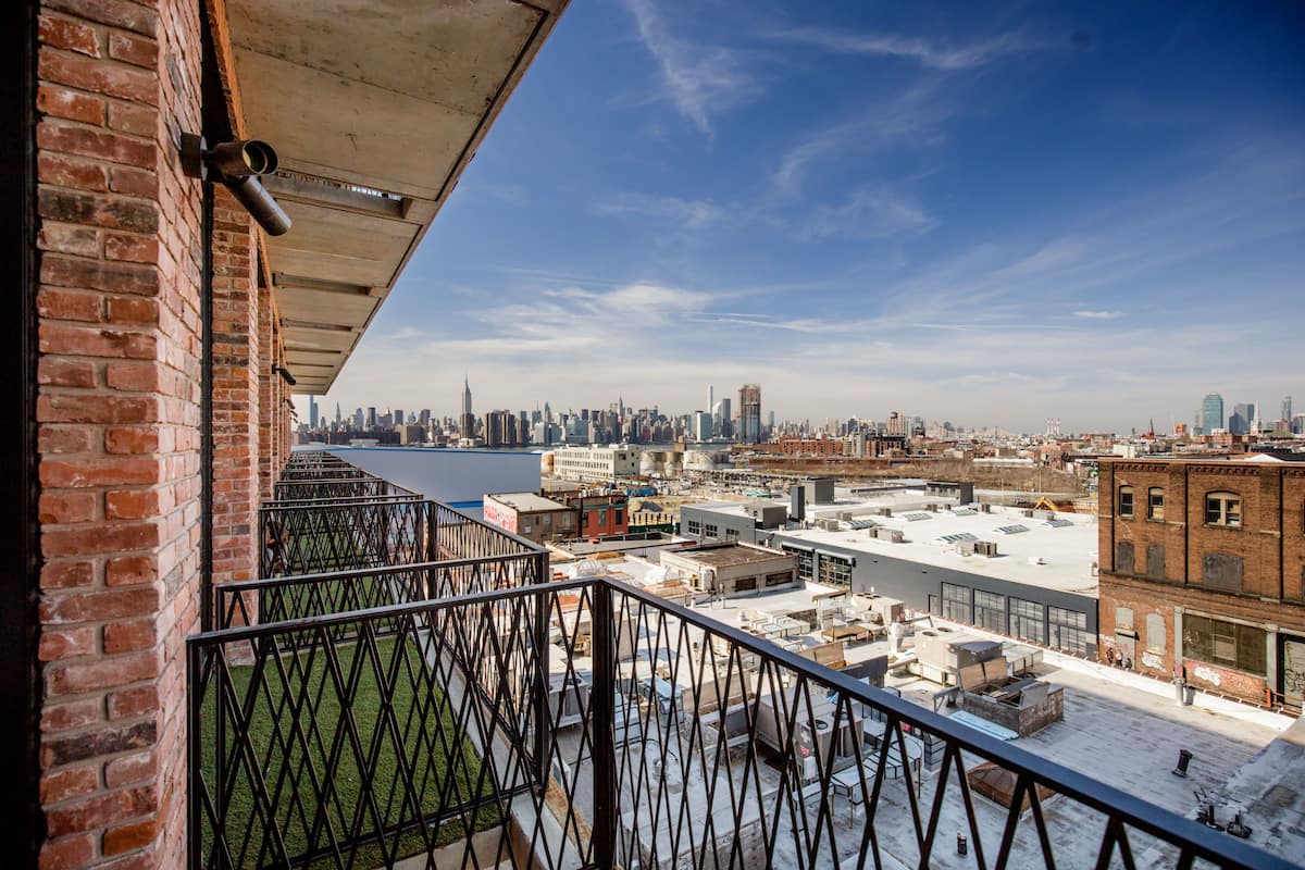 Un edificio alto con vistas a un horizonte urbano, que incluye un río y varios edificios.