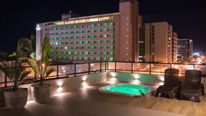 A rooftop pool area with a view of a hotel building in the background. - Amenit Hotel (Maceió)