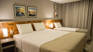 A hotel room with two beds, a wooden headboard, bedside lamps, and framed pictures on the wall. - Amenit Hotel (Maceió)