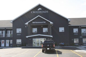 Un edificio con un cartel que dice "Crossroads Inn & Suites" en 980 Kenmount Rd.