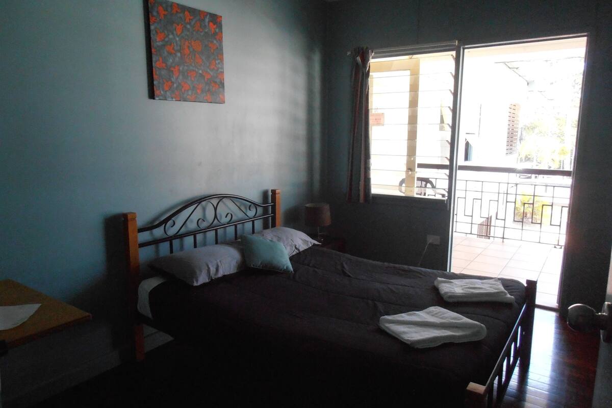 Ein Schlafzimmer mit einem Bett, einem Fenster und einer Tür.
