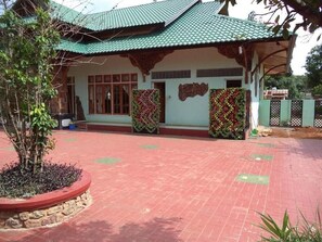 A building with a green roof, a stone base, and a brick-paved entrance. - Hsaung Thazin Hotel Pyin Oo Lwin (Pyin Oo Lwin)