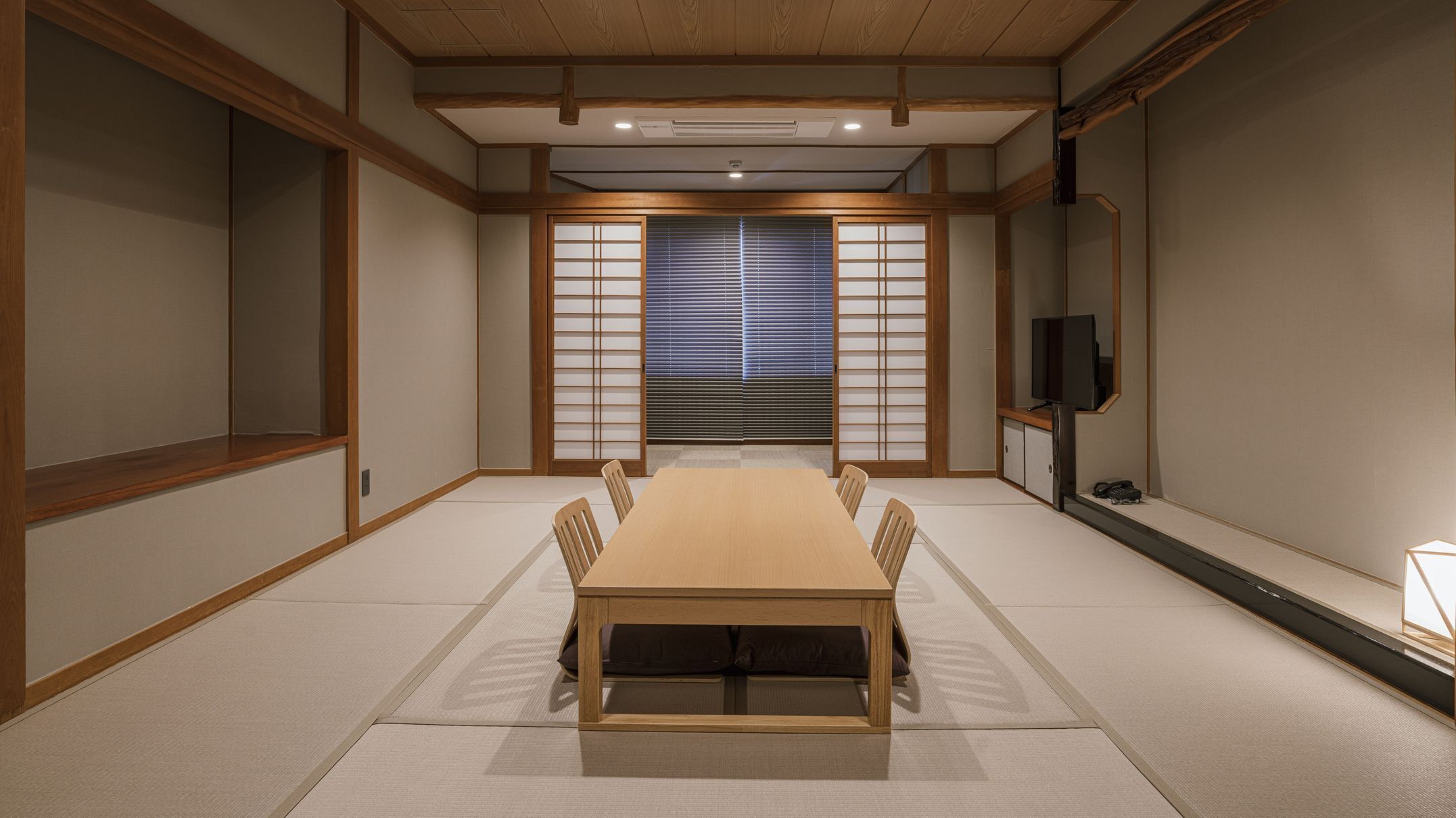 A traditional Japanese-style room with tatami flooring, a low table, and sliding doors.