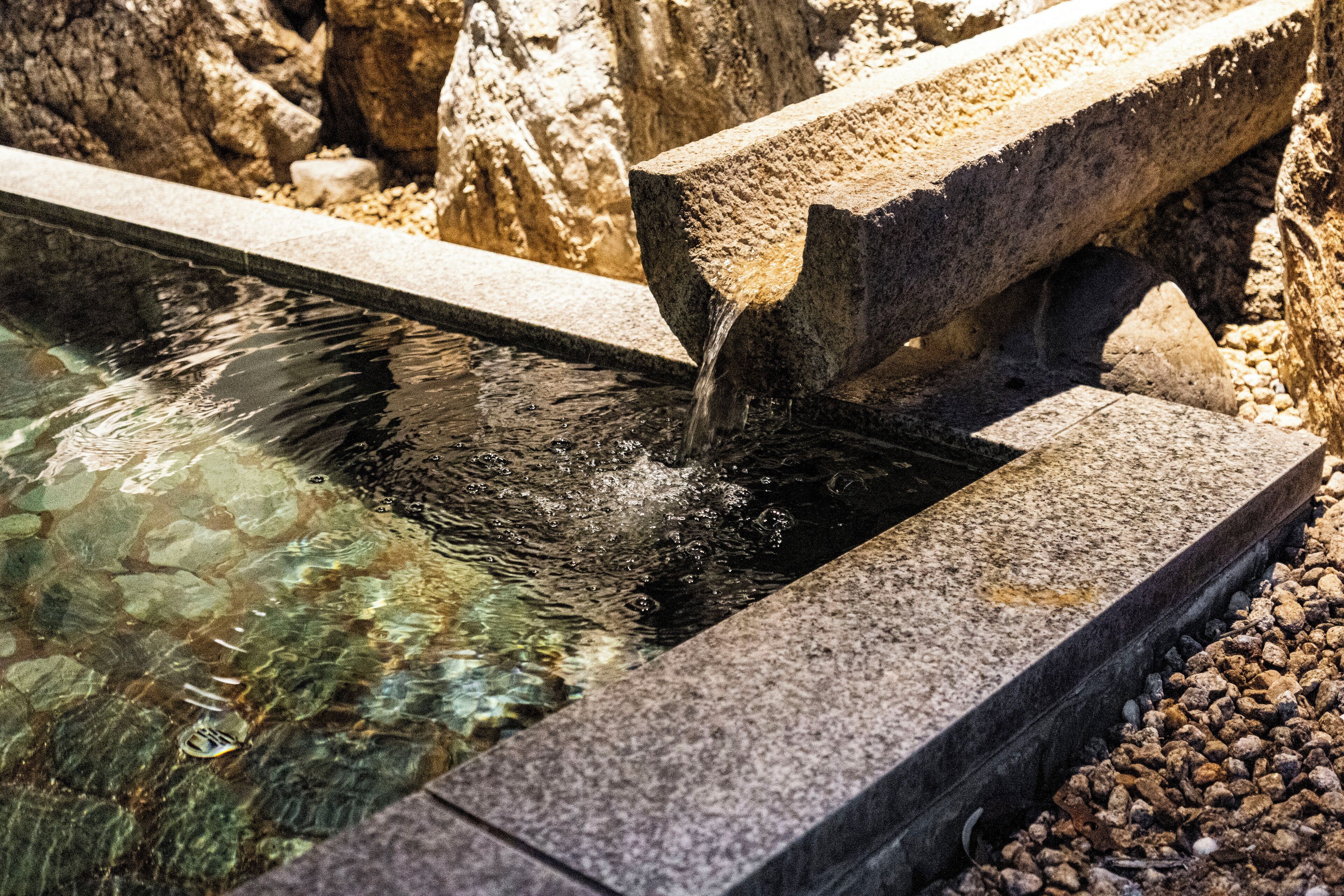 A stone water feature with clear water flowing over it.
