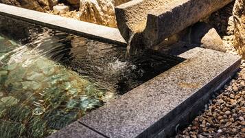 A stone water feature with clear water flowing over it.