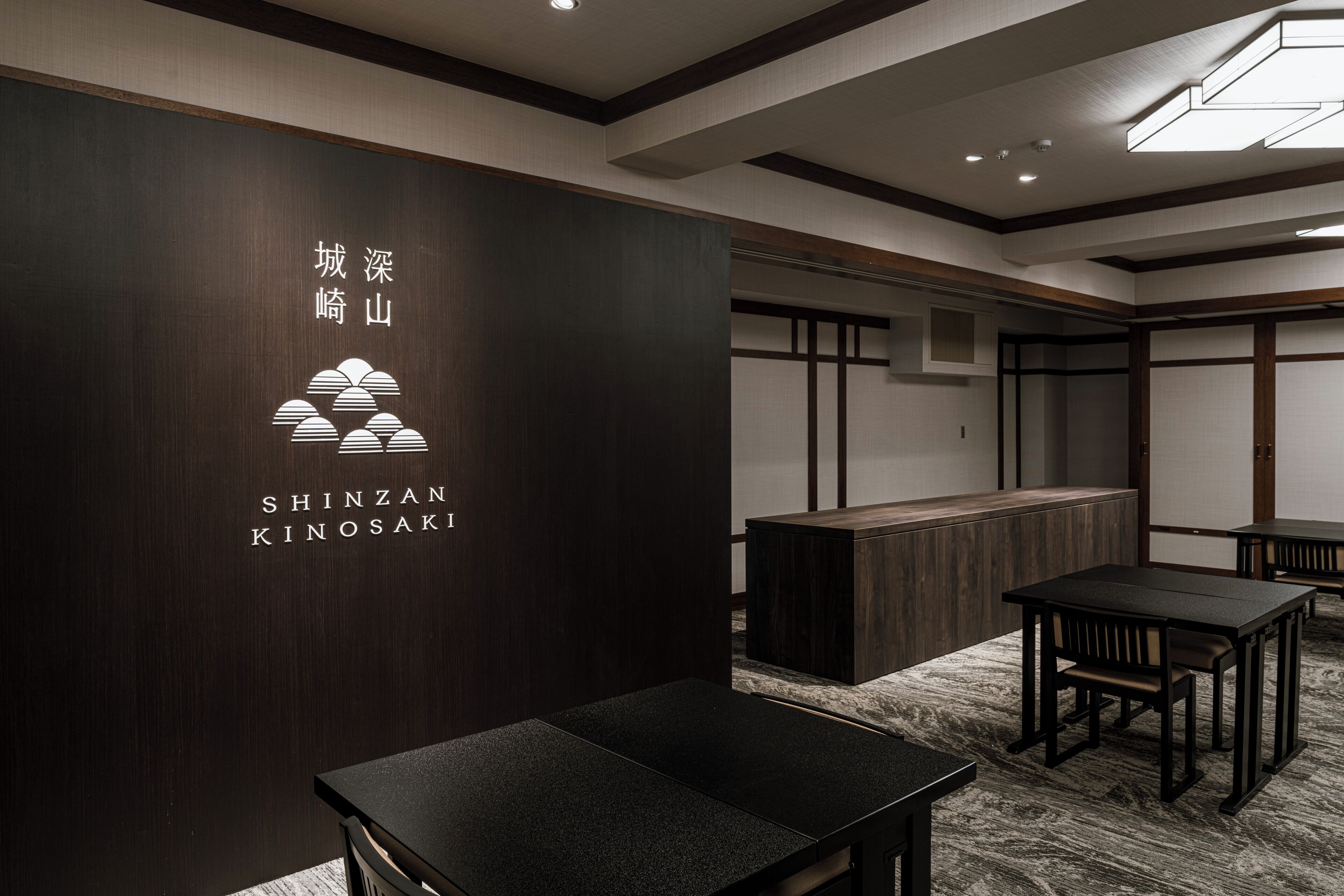A modern interior with a reception desk, seating area, and a wall with signage.