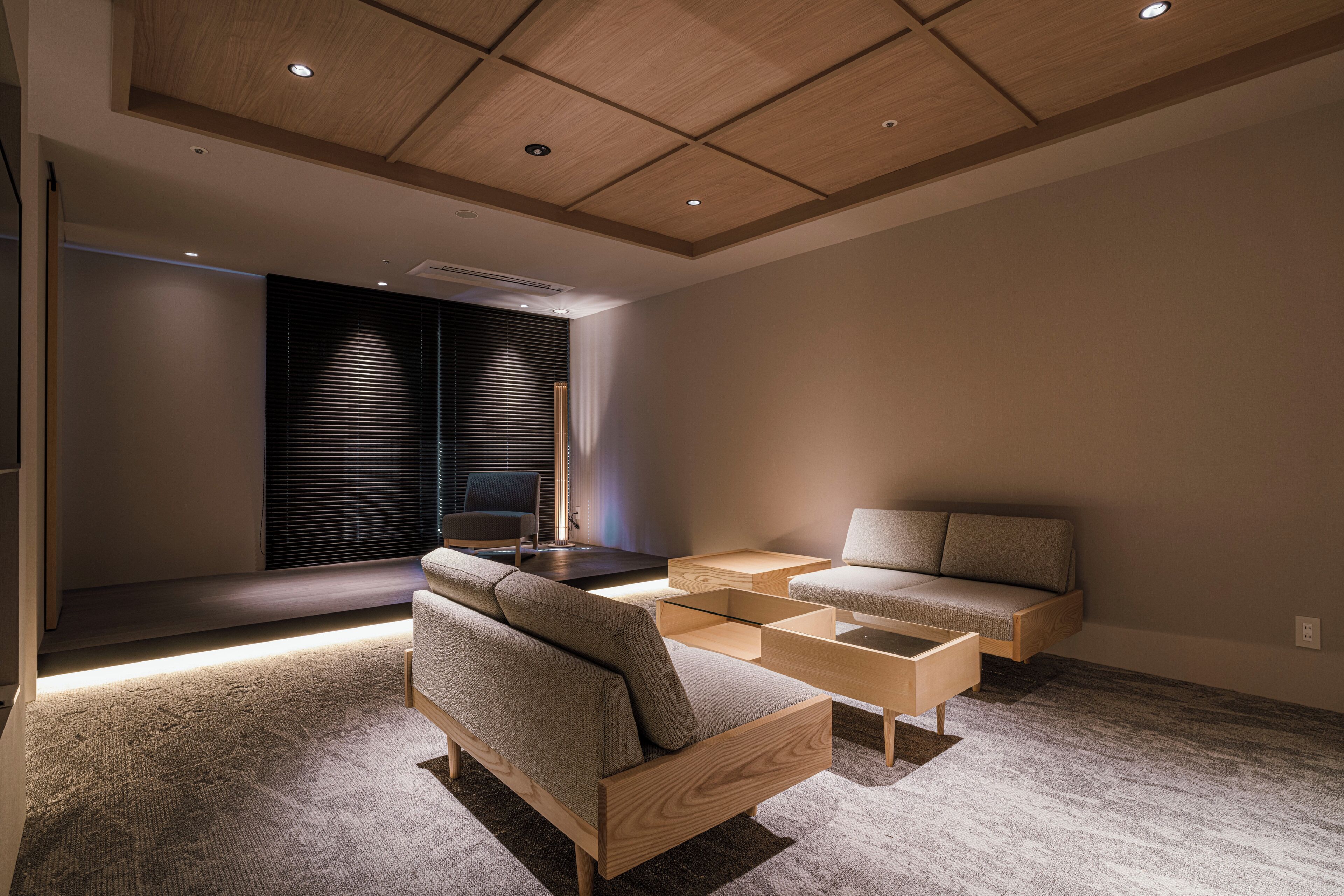 A modern living room with a sofa, a coffee table, and a TV.