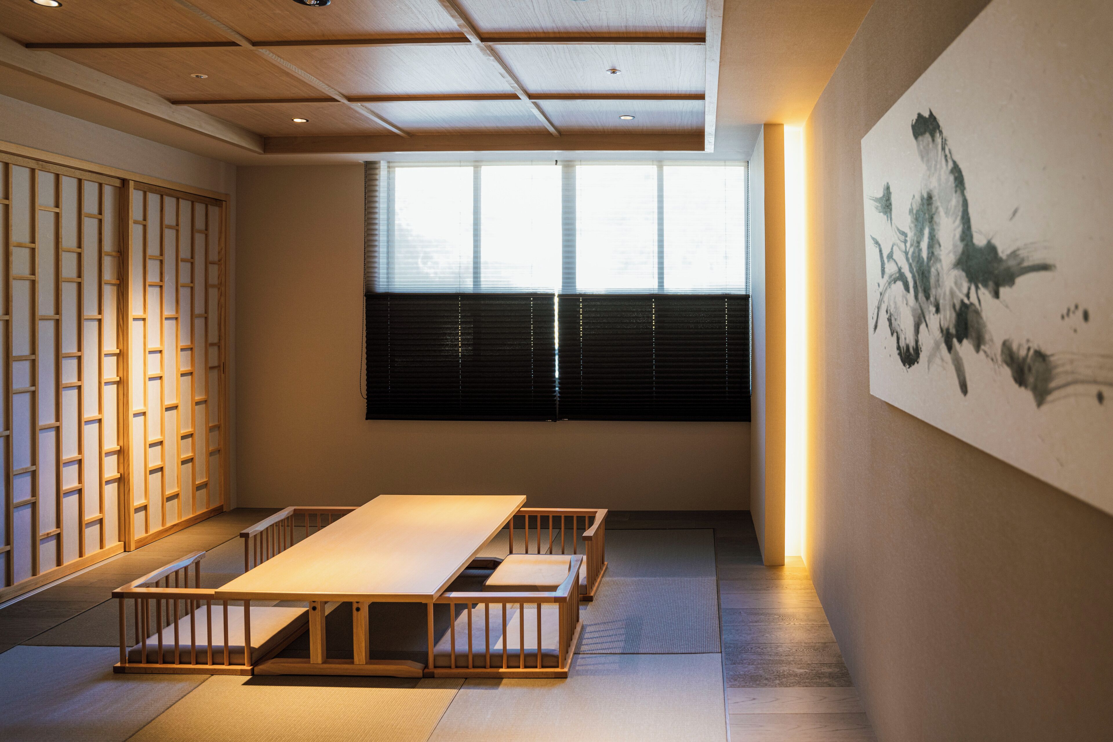 A traditional Japanese room with tatami flooring, a low table, and sliding doors.
