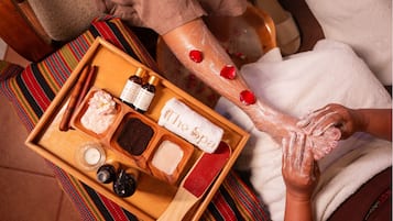 A wooden tray with various spa products including candles, oils, and a towel labeled "The Spa".