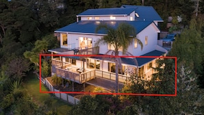 A two-story house with a balcony, surrounded by dense greenery. - Allure Lodge (Paihia)