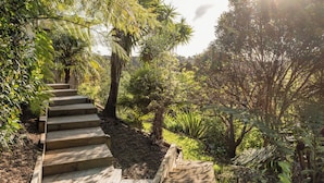 A wooden staircase surrounded by lush greenery and trees. - Allure Lodge (Paihia)