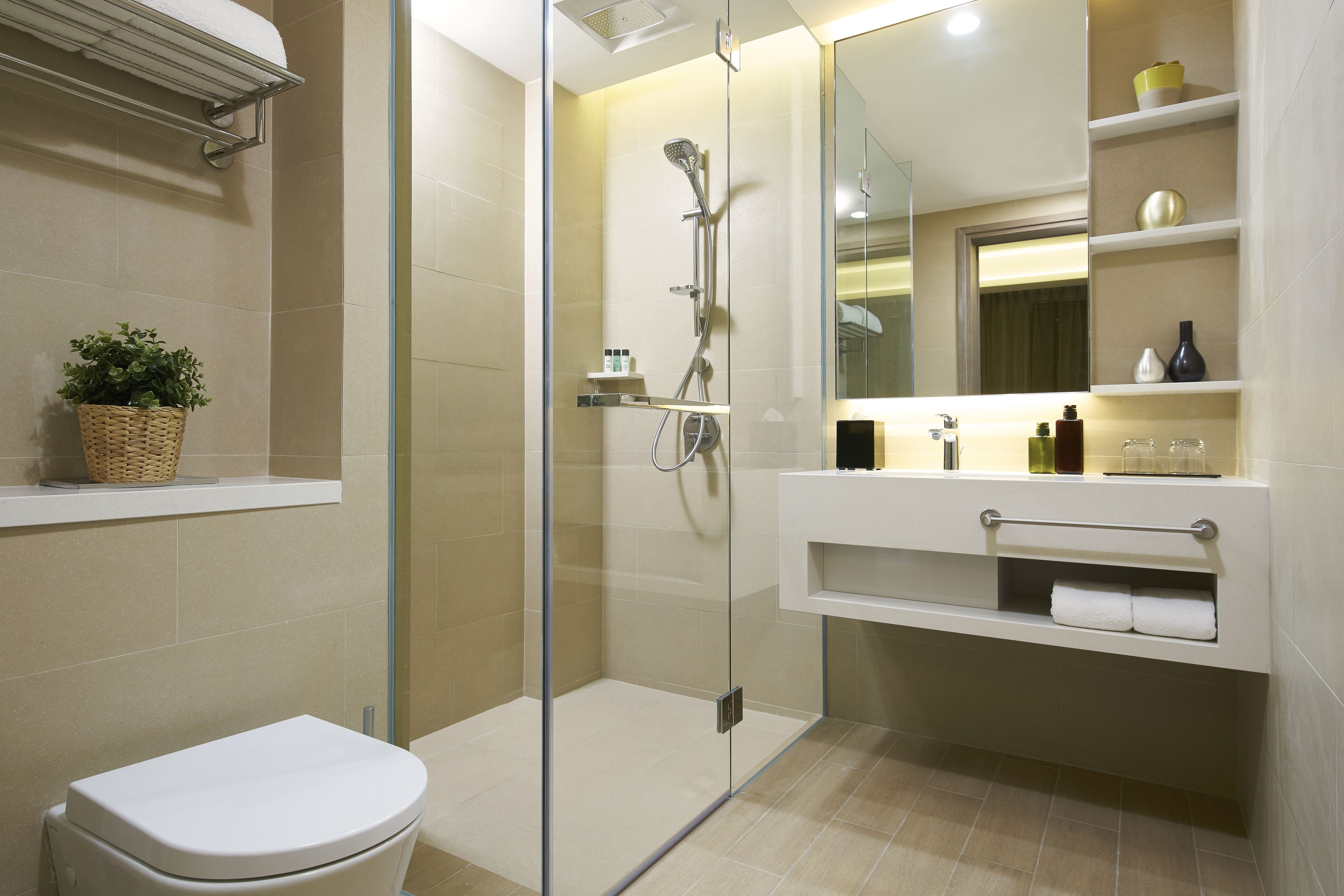 A modern bathroom with a glass-enclosed shower, a toilet, and a vanity with a mirror and shelves.