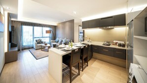 Una cocina moderna con una isla central, electrodomésticos integrados y una zona de comedor con sofá y mesa de centro.