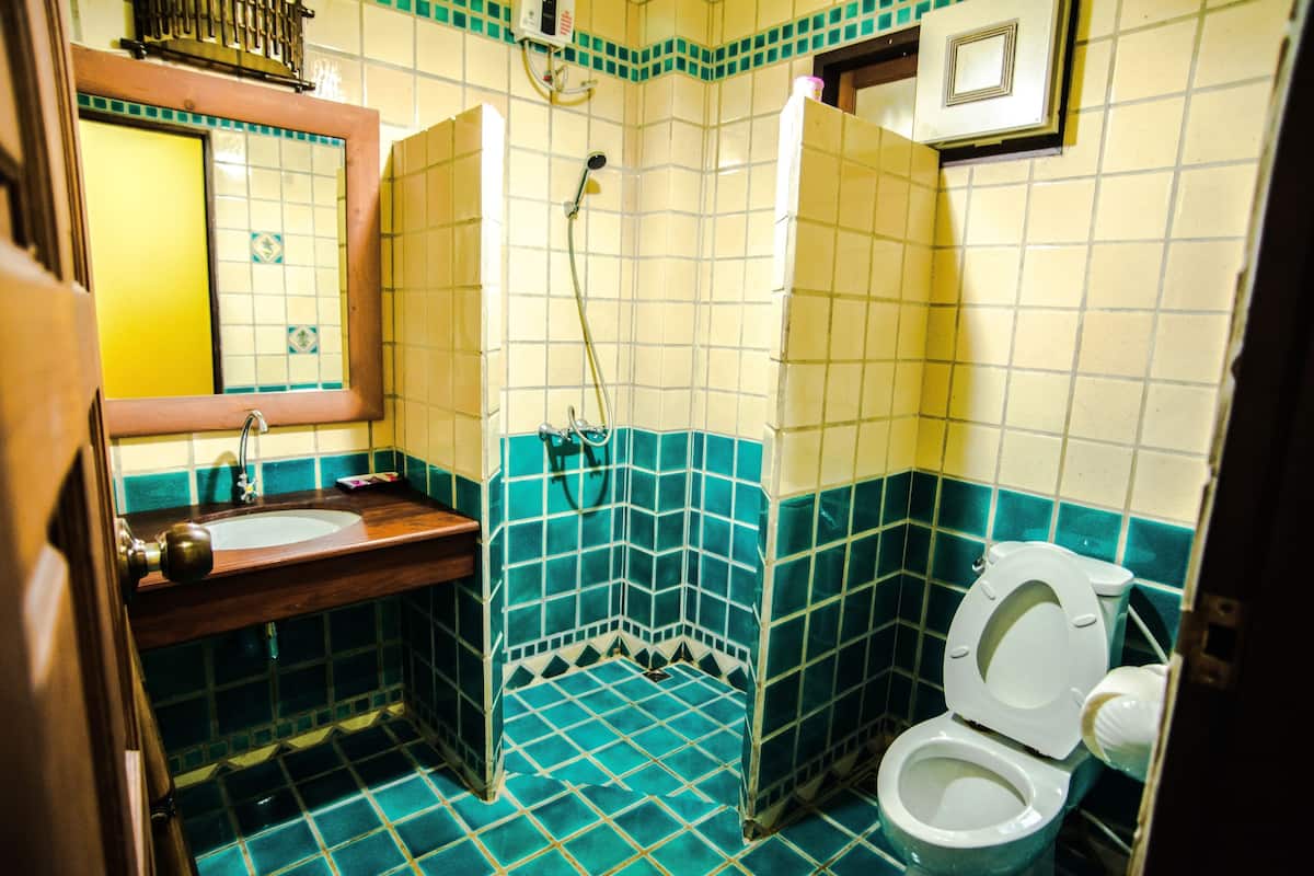 Ein kleines Badezimmer mit Waschbecken, Spiegel, Toilette und Dusche.