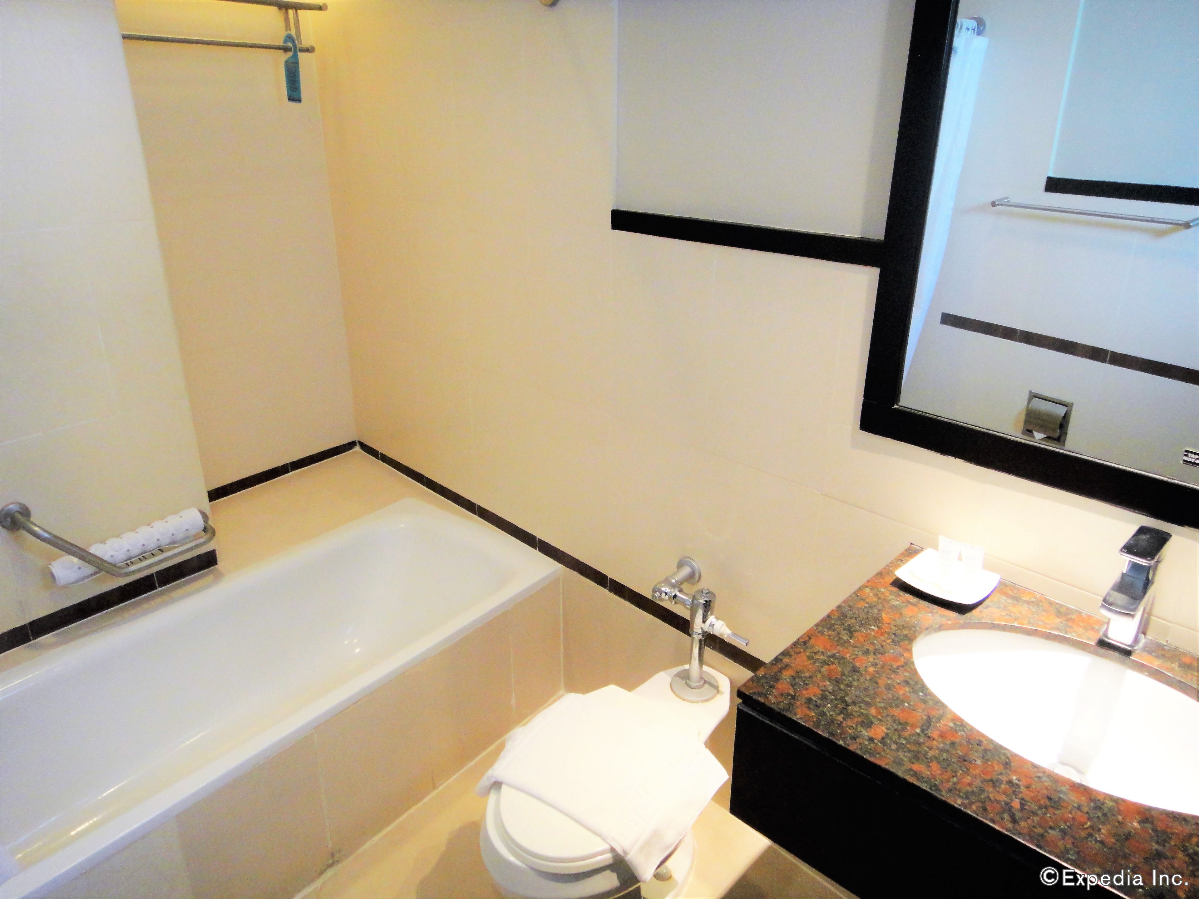 A bathroom with a bathtub, toilet, and sink.