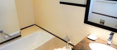 A bathroom with a bathtub, toilet, and sink.