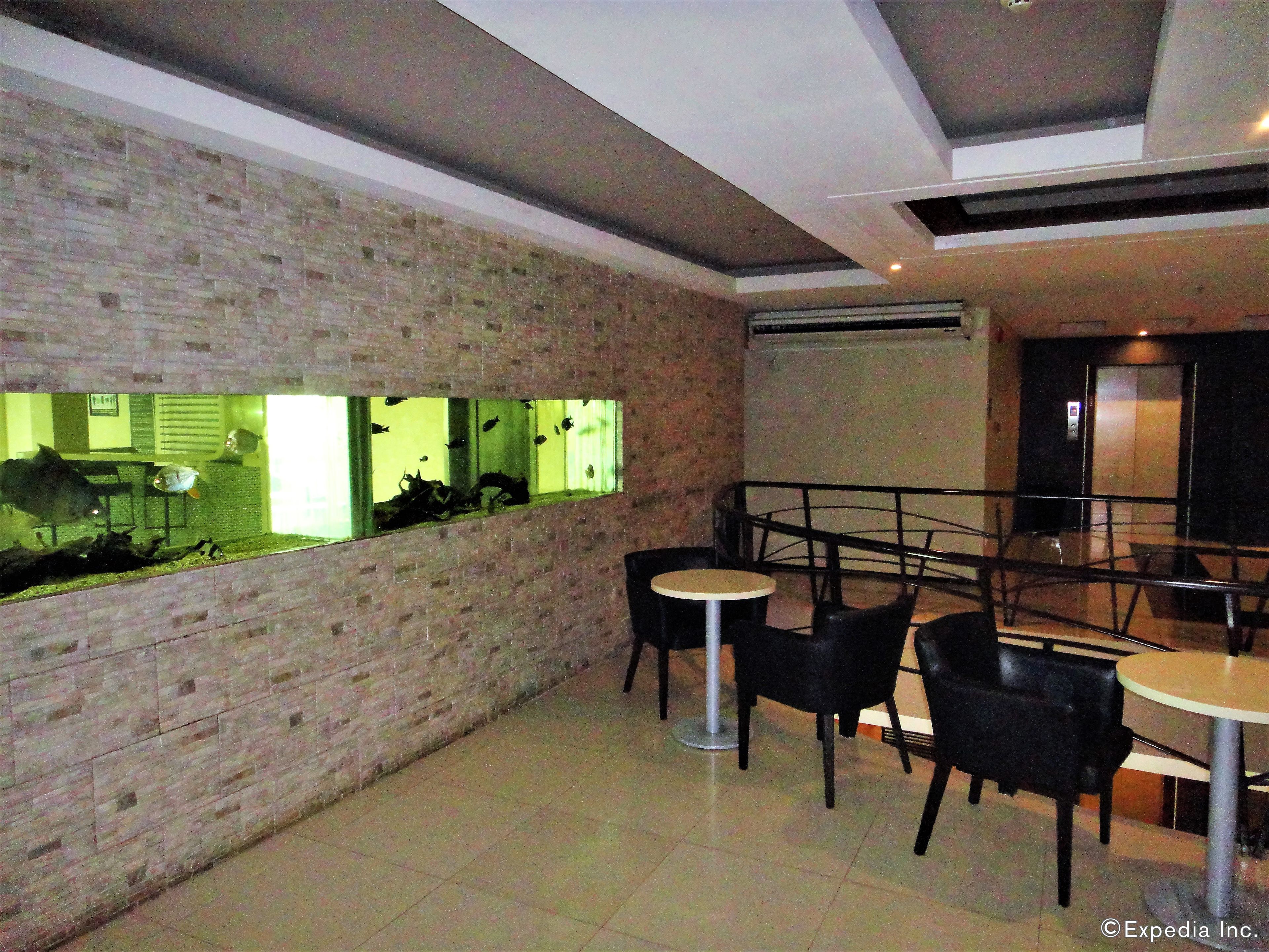 A restaurant with brick walls, a large aquarium window, and modern furniture.