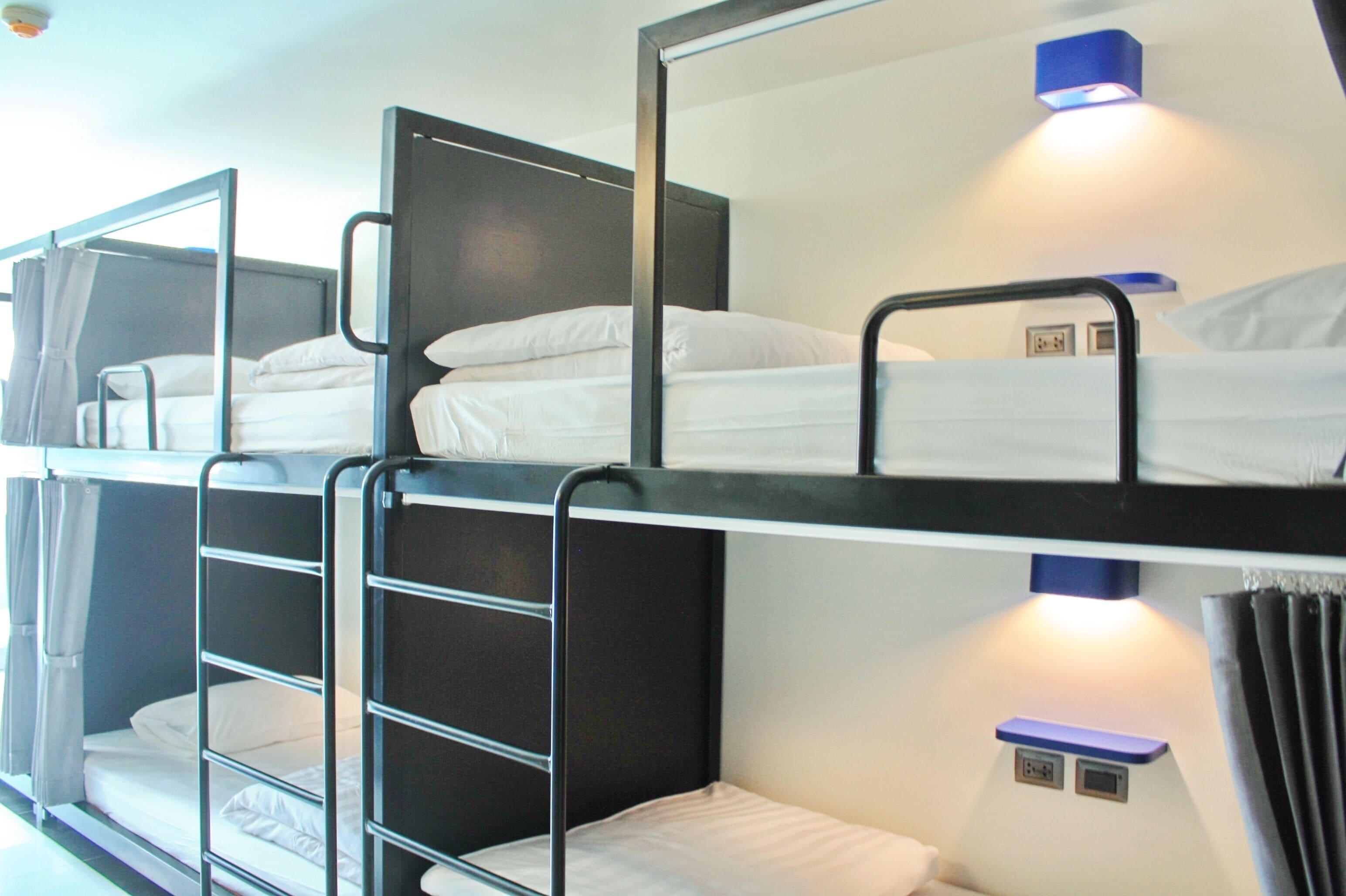 Dormitorio con literas, un espejo y un estante pequeño.