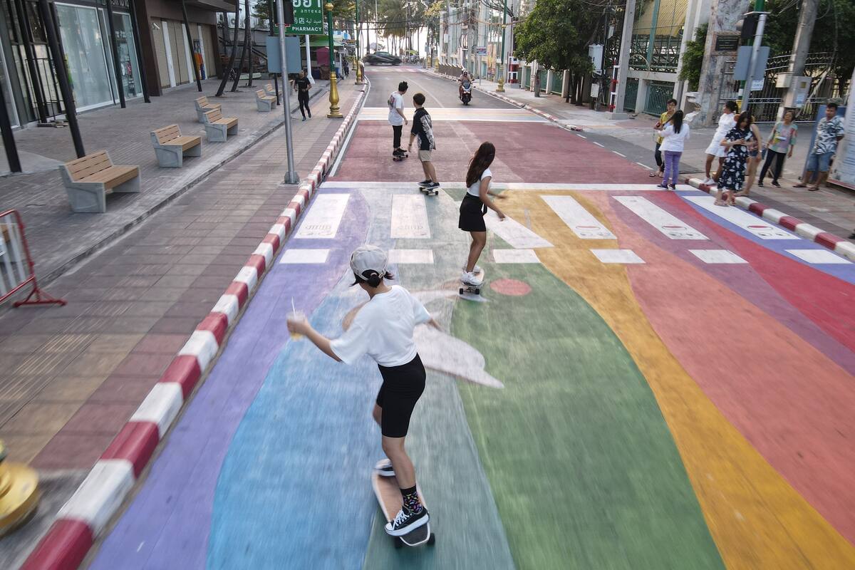 A colorful pedestrian crossing with benches and a pharmacy in the background.