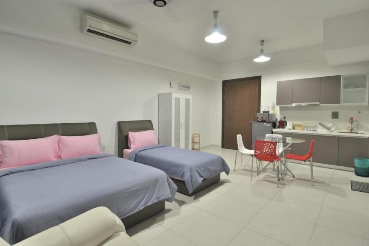 Een moderne hotelkamer met twee bedden, een kitchenette en een eethoek.