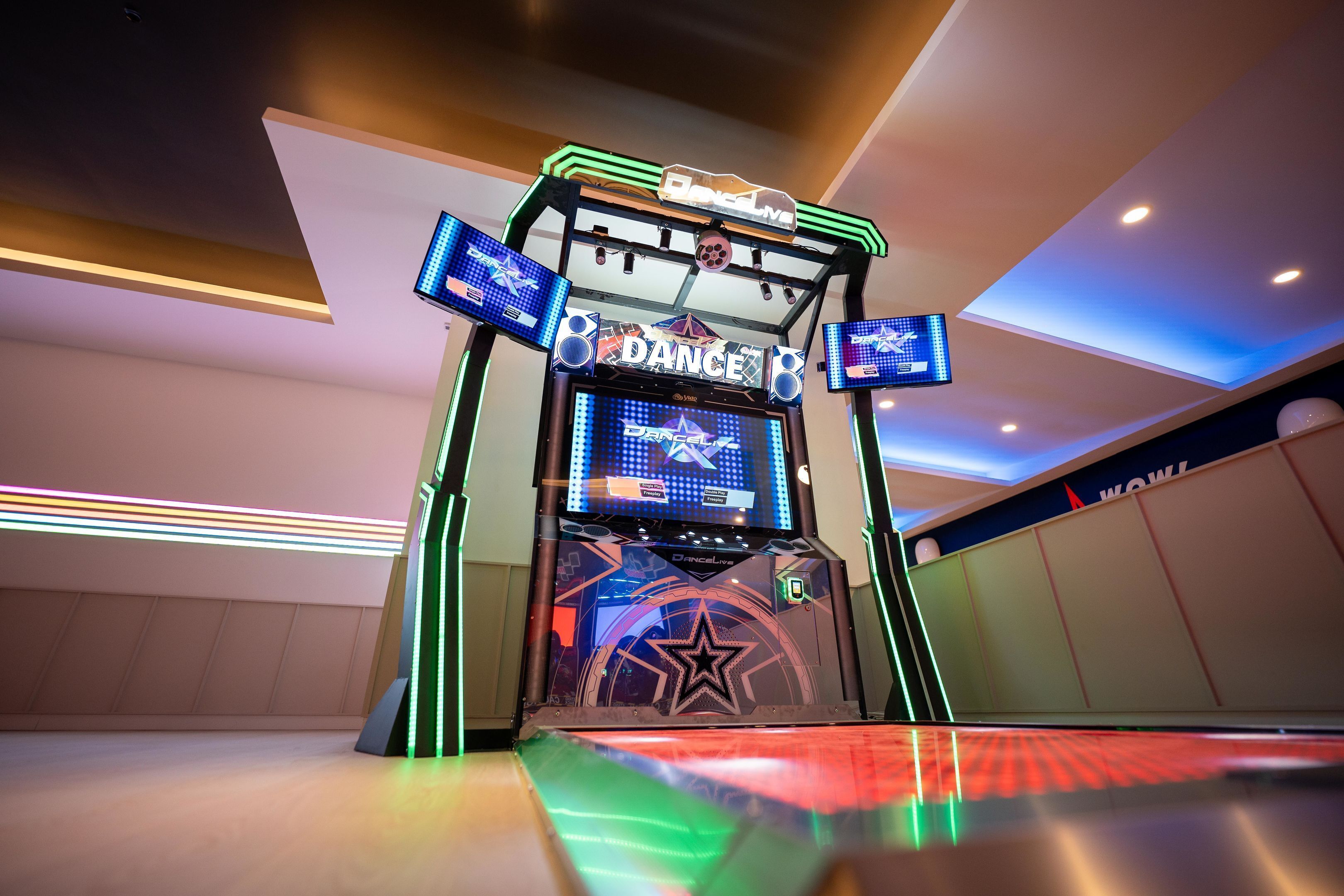 A dance arcade with neon lights and a star logo.