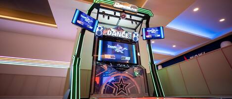A dance arcade with neon lights and a star logo.