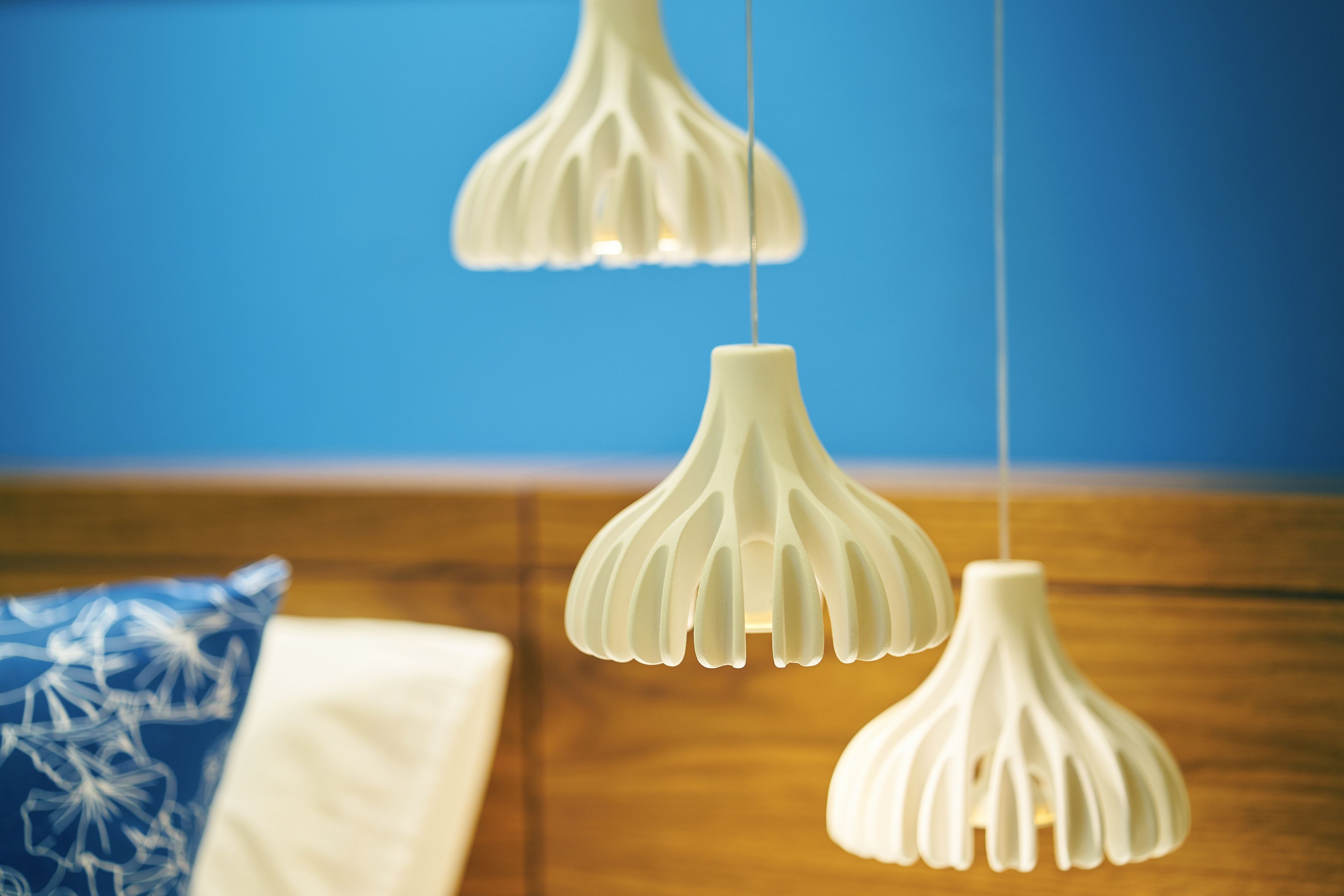 Una habitación con cabecera de madera, almohada blanca y almohada azul con diseño blanco.