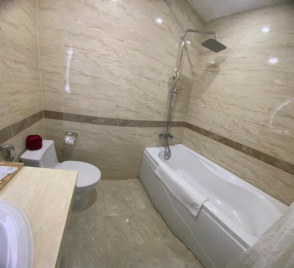 A bathroom with a toilet, a bathtub, and a shower. - Hotel La Perle Hue (Hue)
